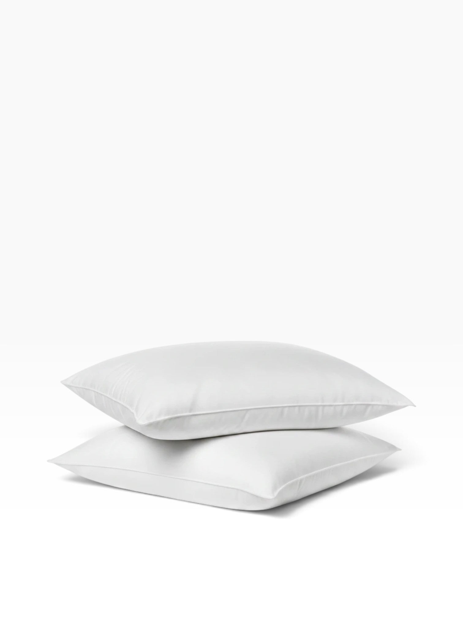Two white Valiant Products Ultra Touch recycled fiber pillows stacked on a plain white background.