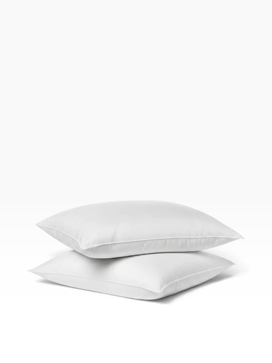 Two white Valiant Products Ultra Touch recycled fiber pillows stacked on a plain white background.