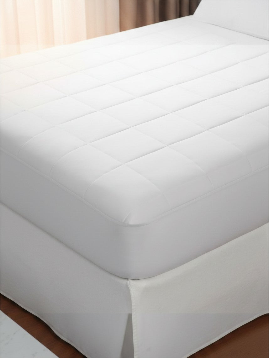 Valiant Products Silent Choice Plus white quilted waterproof mattress pad with soft microfiber surface on a bed